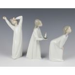 A Lladro figure of a yawning boy 21cm, ditto of a bending girl 18cm and another of a girl holding