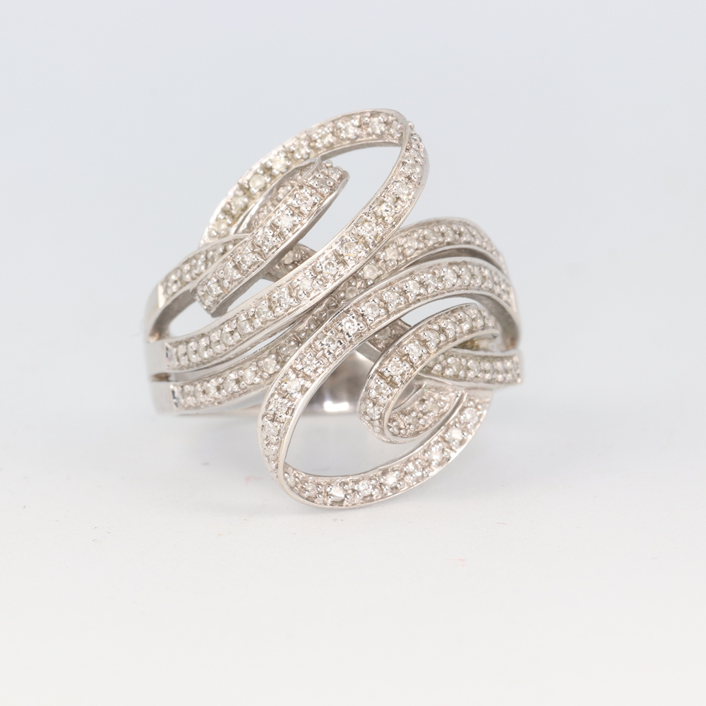 A stylish 18ct white gold whorl diamond set cocktail ring, 11.8 grams, size U