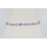 A white metal 18k tanzanite and diamond line bracelet, the tanzanites 8.85ct, the brilliant cut