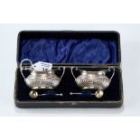 A PAIR OF GEORGE V SILVER DOUBLE HANDLED SALT CELLARS together with matching SALT SPOONS,