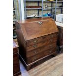 A GEORGE III COUNTRY MADE FRUITWOOD BUREAU, the fall front above four long graduated drawers,