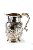 A LARGE LATE VICTORIAN SILVER JUG with embossed foliate and scroll decoration and leaf capped