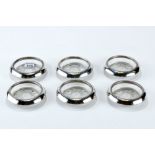 A SET OF SIX CIRCULAR WINE GLASS COASTERS with sterling silver rims, each 4" diameter.