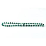 A STRING OF GRADUATED MALACHITE BEADS, 23" long.