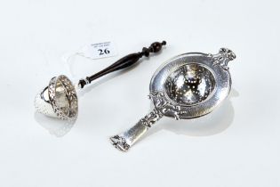 AN UNUSUAL CONTINENTAL SILVER STRAINER with pierced rim and turned mahogany handle,