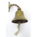A brass bell with wall mount Please Note - we do not make reference to the condition of lots