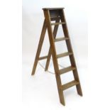 A mid 20thC folding step ladder. Approx. 58" high Please Note - we do not make reference to the