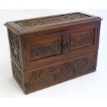 An Oriental carved hardwood box with twin doors and lift lid, with carved dragon and floral