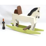 A scratch built and painted wooden rocking horse on bows with brown painted back and foot rest.