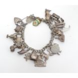 A silver and silver plate charm bracelet Please Note - we do not make reference to the condition