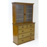 An early 20thC mahogany bookcase with a moulded cornice above two glazed doors containing three