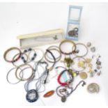 A quantity of assorted costume jewellery to include bangles, necklaces, a silver ring, earrings,