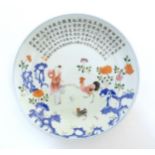 A Chinese famille rose plate decorated with a figure, a cockerel, hen and chicks in a garden with