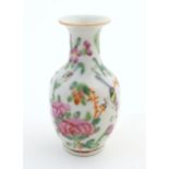 A small Chinese famille rose baluster vase decorated with butterflies amongst flowers and foliage.