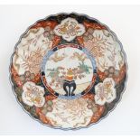 An Oriental charger with scalloped edge in the Imari palette decorated with a stylised censor on