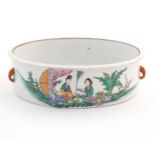 A Chinese dish of circular form decorated with two female figures reading on a garden terrace, and