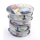 A Chinese four tier lidded porcelain food container of cylindrical form decorated with flowers and