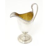 A Geo III silver helmet shaped cream jug with gilded interior. Hallmarked London 1792 . Approx. 6"