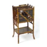 A late 19thC aesthetic movement magazine rack with turned bamboo supports and having decorated