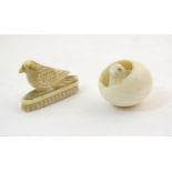A 19thC carved ivory model of a chick hatching from an egg, and a carved model of a bird with