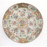 A Chinese / Cantonese famille rose charger decorated with flowers, foliage, birds, butterflies, etc.