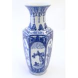 An Oriental blue and white vase with panelled decoration depicting landscapes, birds perched on