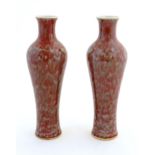 A pair of Chinese vases of elongated form decorated with a mottled glaze. Double ring mark under.