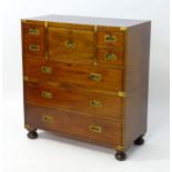 An early / mid 19thC mahogany campaign chest with brass caps and corner mounts, the chest comprising