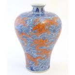 A Chinese Meiping style vase decorated with red dragons amongst stylised waves. Character marks