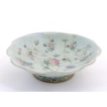 A Chinese / Cantonese foot dish with scalloped edge decorated with flowers, foliage and insects.