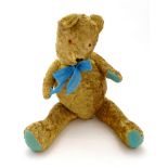 Toy: A large early 20thC straw filled teddy bear with stitched nose and mouth, articulated limbs,