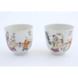 A pair of Chinese tea cups decorated with figures in a garden terrace with two birds. Character