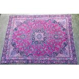 Carpet / Rug : A fuchsia coloured ground carpet with central medallion decorated with blue, cream,