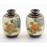 A pair of small Japanese vases decorated with flowers and foliage with gilt highlights. Character