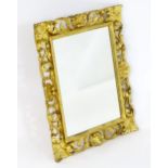 A giltwood mirror with a floral carved and pierced frame and a bead moulded surround. 23" wide x 27"