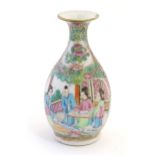 A Cantonese famille rose bottle vase with a flared rim decorated with figures on a terrace with a