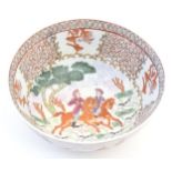 A Chinese bowl decorated with landscape scenes depicting figures on horseback hunting with gun dogs.