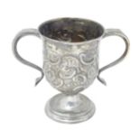 A George III silver twin handled pedestal cup / loving cup with embossed decoration, hallmarked