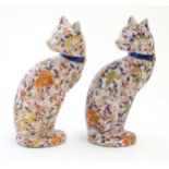 A pair of Oriental models of cats decorated in the Imari palette with flowers, foliage and gilt