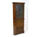 A 19thC mahogany corner cupboard with a moulded cornice above an unusually moulded astragal glazed