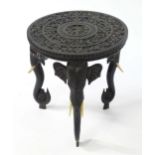 A late 19thC Indian table with a carved top showing banded floral decoration with a carved figural