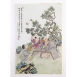 A Chinese porcelain plaque decorated with three seated male figures in a garden terrace watching
