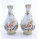 A pair of Chinese famille rose bottle vases decorated with seated figures on a garden terrace,