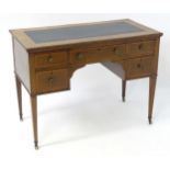 An early 20thC mahogany writing desk with a crossbanded top and an inset writing section, having a
