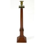 A large late 19thC turned mahogany candlestick of column form with a stepped base and a brass