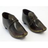 A pair of 19thC children's leather clogs with stud detail and wooden and metal soles. Approx. 2 1/2"