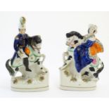 A pair of Victorian Staffordshire pottery figures depicting Albert and Victoria on horseback.