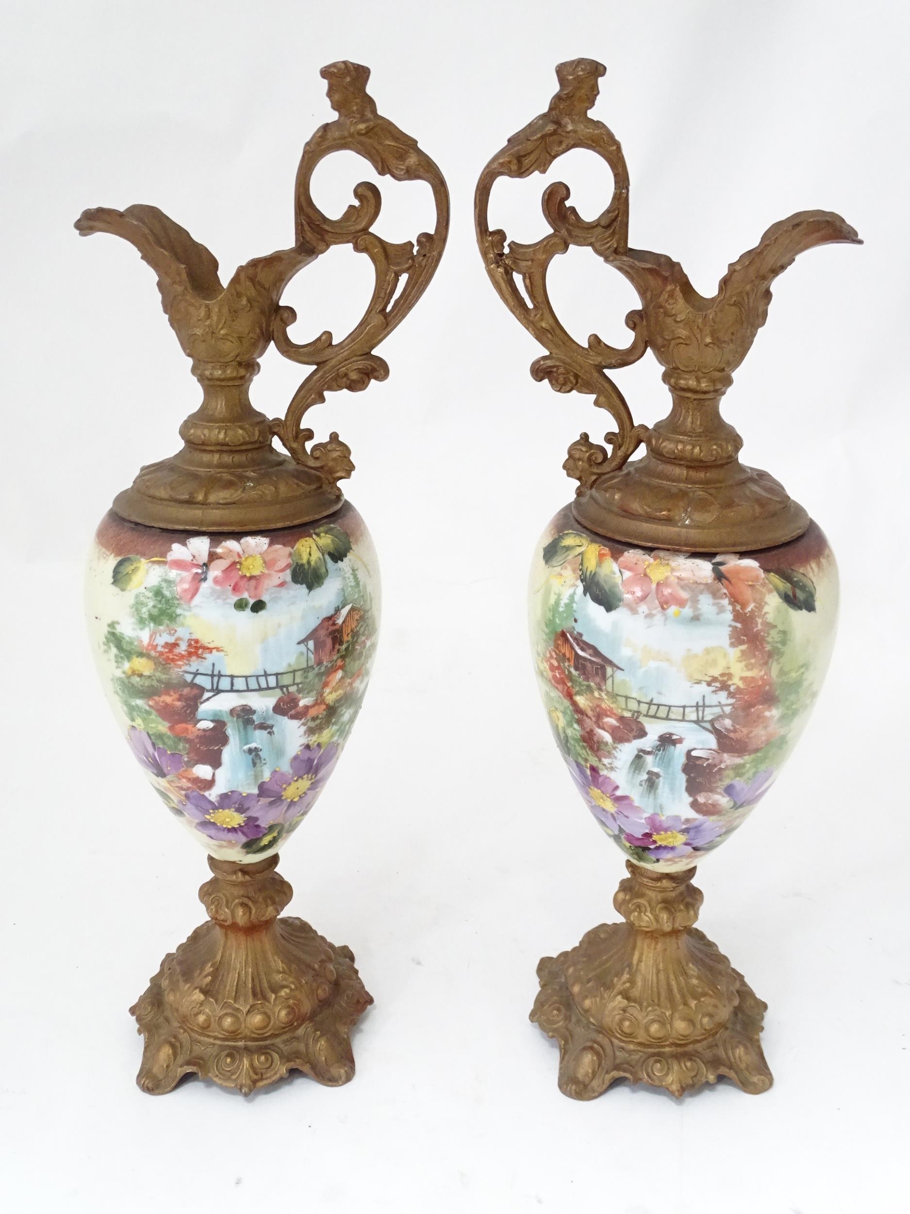 A pair of hand painted glass ewers with gilt metal mounts. Approx. 21" high (2) Please Note - we