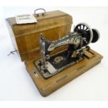 An early 20thC portable sewing machine by Frister and Rossman, walnut base and case, 19" long Please