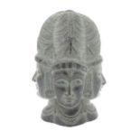 A carved soapstone model of the Hindu Trimurti depicting the heads of Brahma, Vishnu and Shiva, with